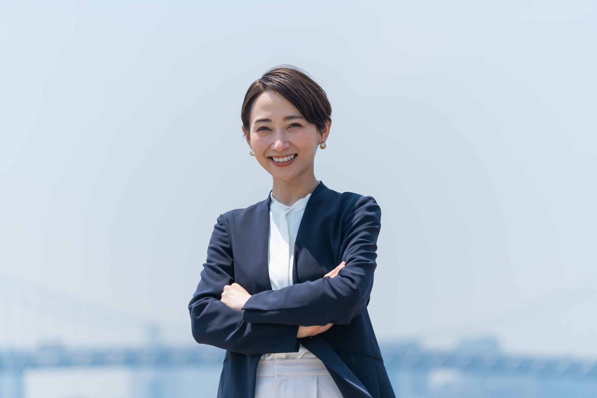 介護と障害福祉専門の税理事務所のイメージ画像_青空の下に腕組みをして立つ税理士の女性